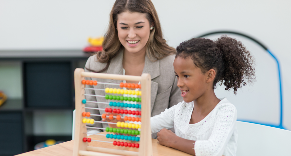 Child playing with counting toy with therapist