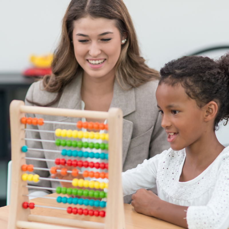 Child playing with counting toy with therapist