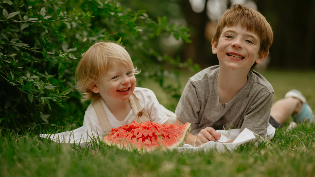 kids eating watermelon in the grass