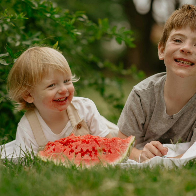 kids eating watermelon in the grass